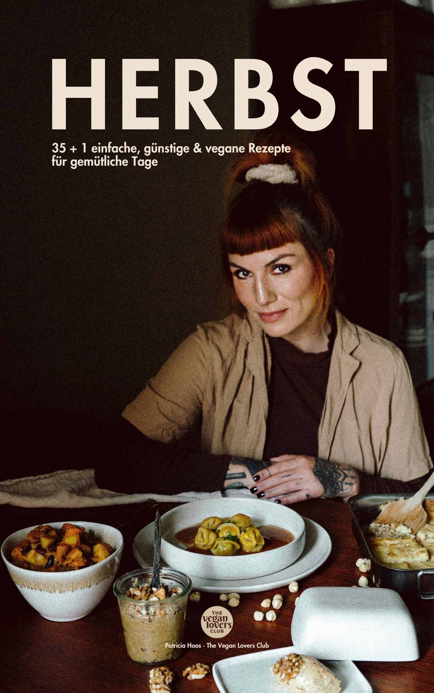 Cover des veganen Kochbuchs HERBST – 35 + 1 einfache, günstige & vegane Rezepte für gemütliche Tage von Patricia Hoos, Gründerin von The Vegan Lovers Club. Das Bild zeigt Patricia an einem gedeckten Tisch mit herbstlichen Gerichten in warmem Licht – stimmungsvoll, natürlich und cozy.