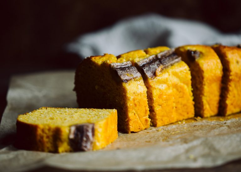 Saftiges Kürbis Bananenbrot mit halbierter Banane auf der Oberfläche, frisch in einer Kastenform gebacken