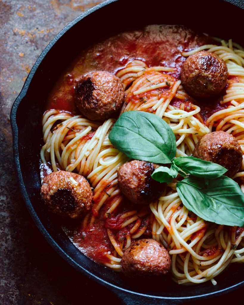 Vegane Meatballs mit Spaghetti in pikanter Tomatensauce auf Teller serviert