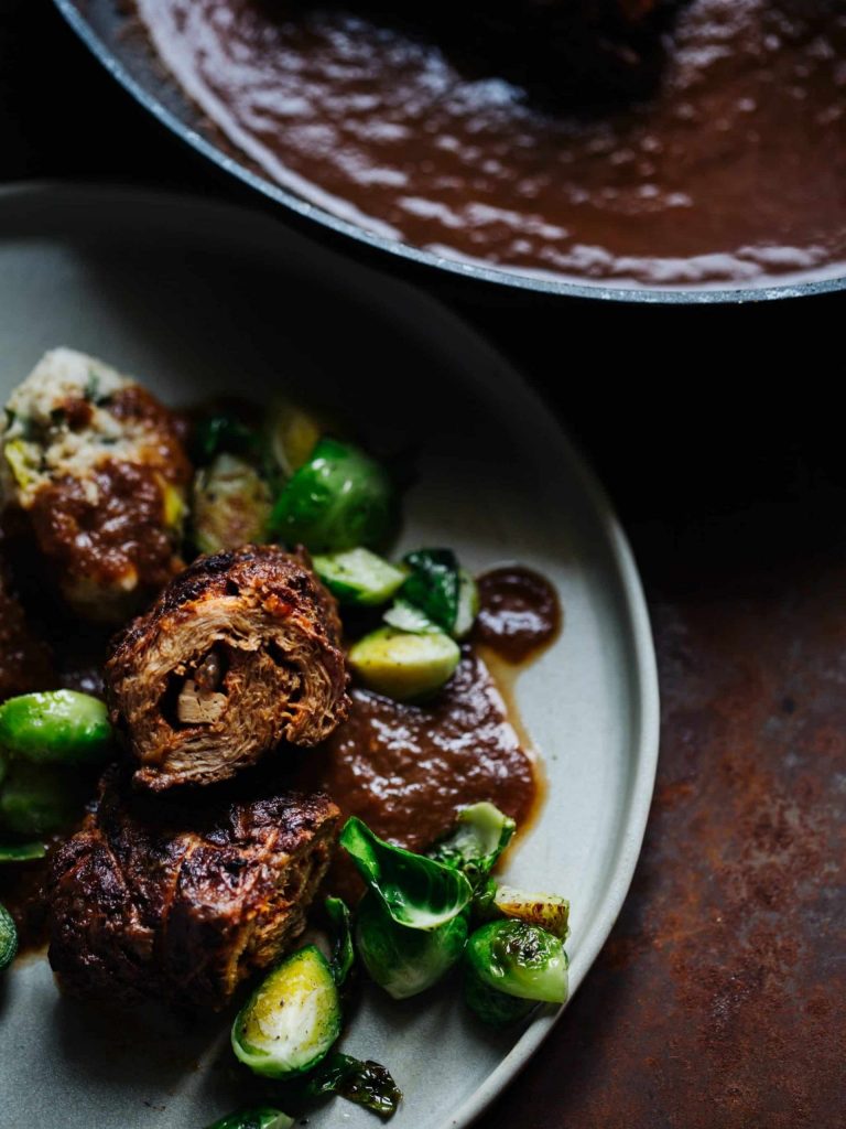 Vegane Rouladen aus Soja mit Füllung und dunkler Bratensauce auf einem Teller serviert