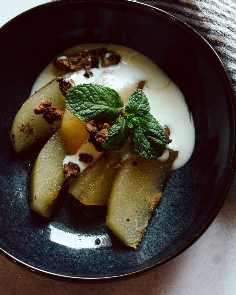 Geschmorte Nashi in Cider serviert mit Zimt-Crumble und Zitronenjoghurt in einer Dessertschale