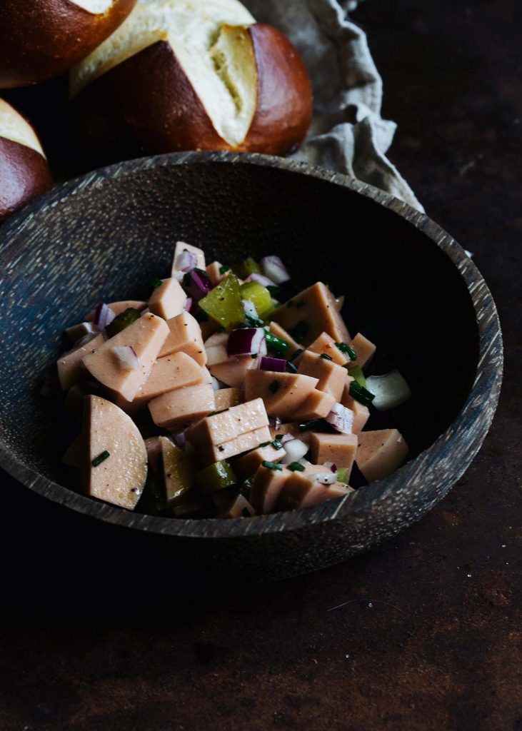 eganer Wurstsalat mit Gewürzgurken, roter Zwiebel und Schnittlauch in einer Schüssel