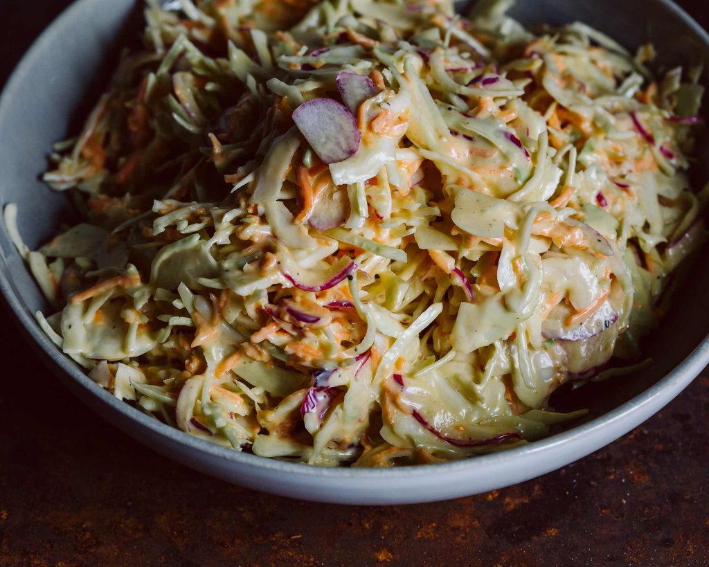 Veganer Coleslaw mit Weißkohl und Karotten in cremigem Dressing