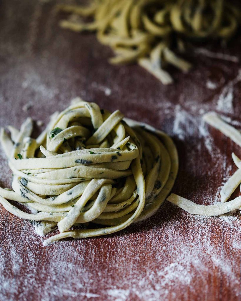 Selbstgemachte vegane Linguine mit Basilikum, Tomaten und Knoblauch